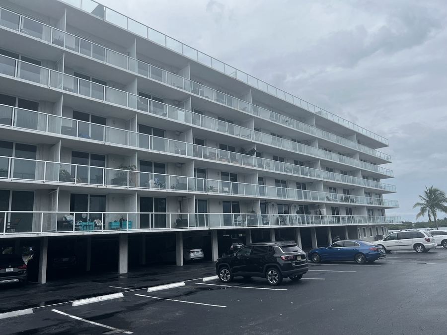 Multi-story building with balconies and railings undergoing restoration