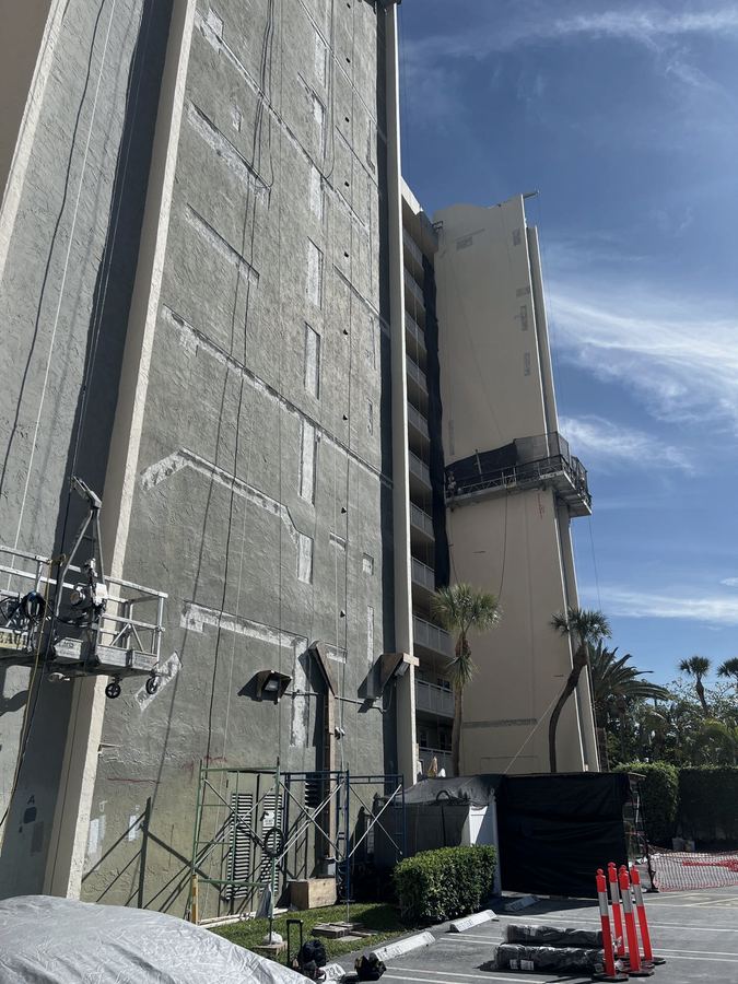 High-rise facade under concrete restoration with a suspended swing stage