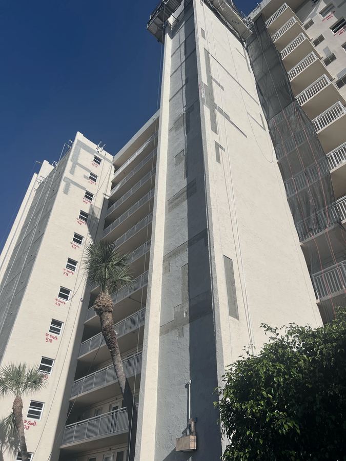 Building facade with marked repair areas during recertification