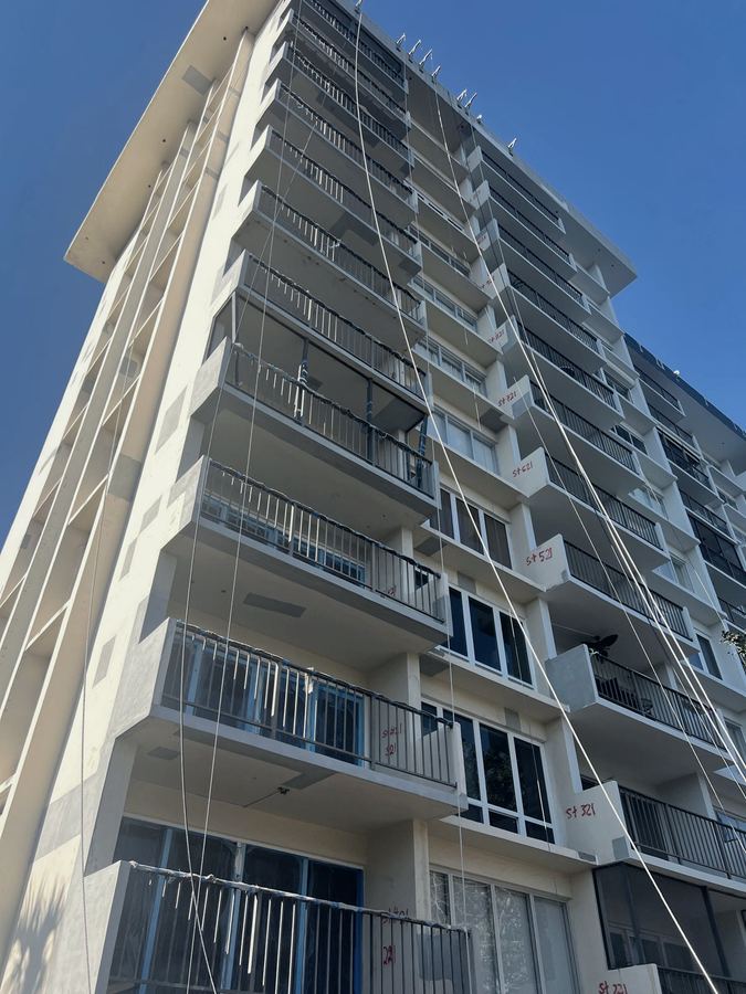 High-rise balcony and railing restoration with marked repair areas
